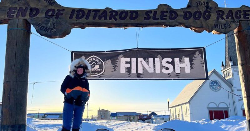 faye norby smiling at the finish line of the iditarod sled dog race