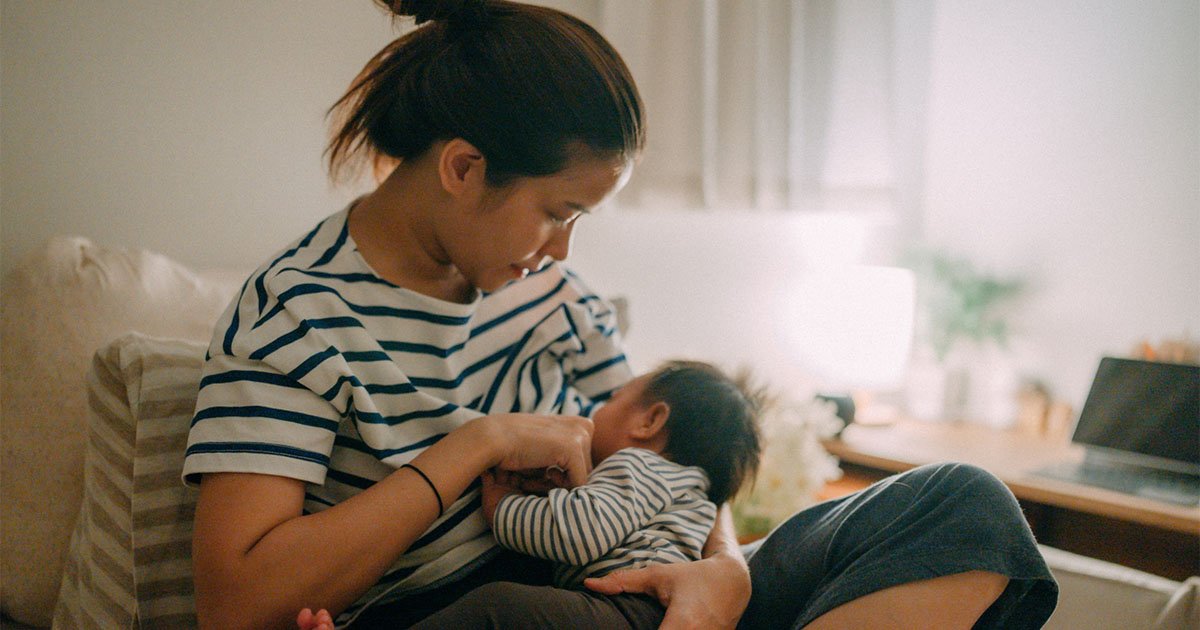 Mother seated on a chair breastfeeding baby