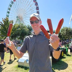 SPH Associate Professor Bjorn Berg holding four pronto pups at the MN State Fair