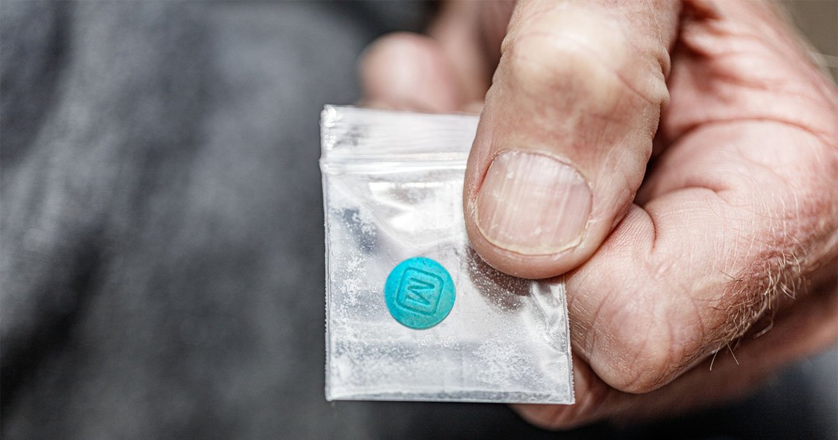 hand holding a fentanyl opiate in plastic bag