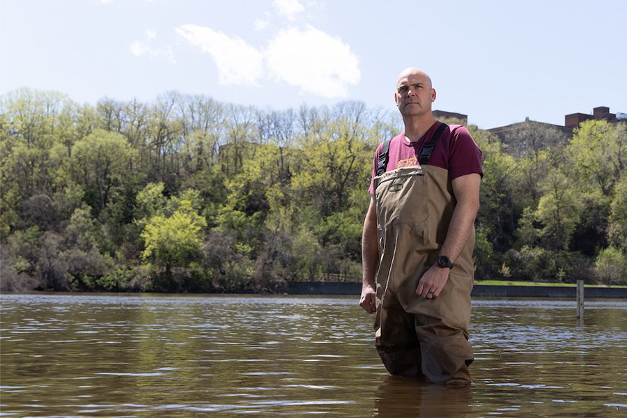 person standing in river with waders on