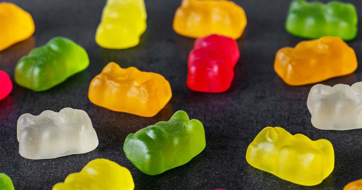 Multicolored gummi bears on a black table